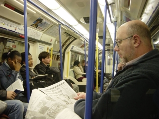 Guy reading newspaper in London